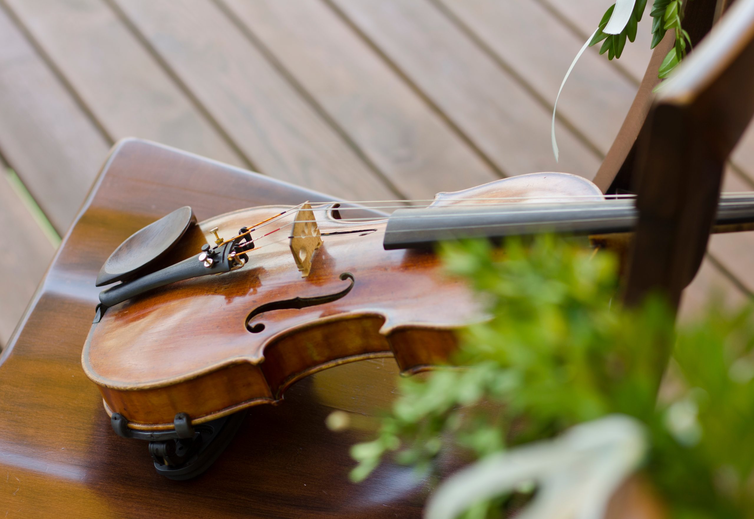 Beautiful violin on a wooden chair. Musical instrument. Wedding decorations