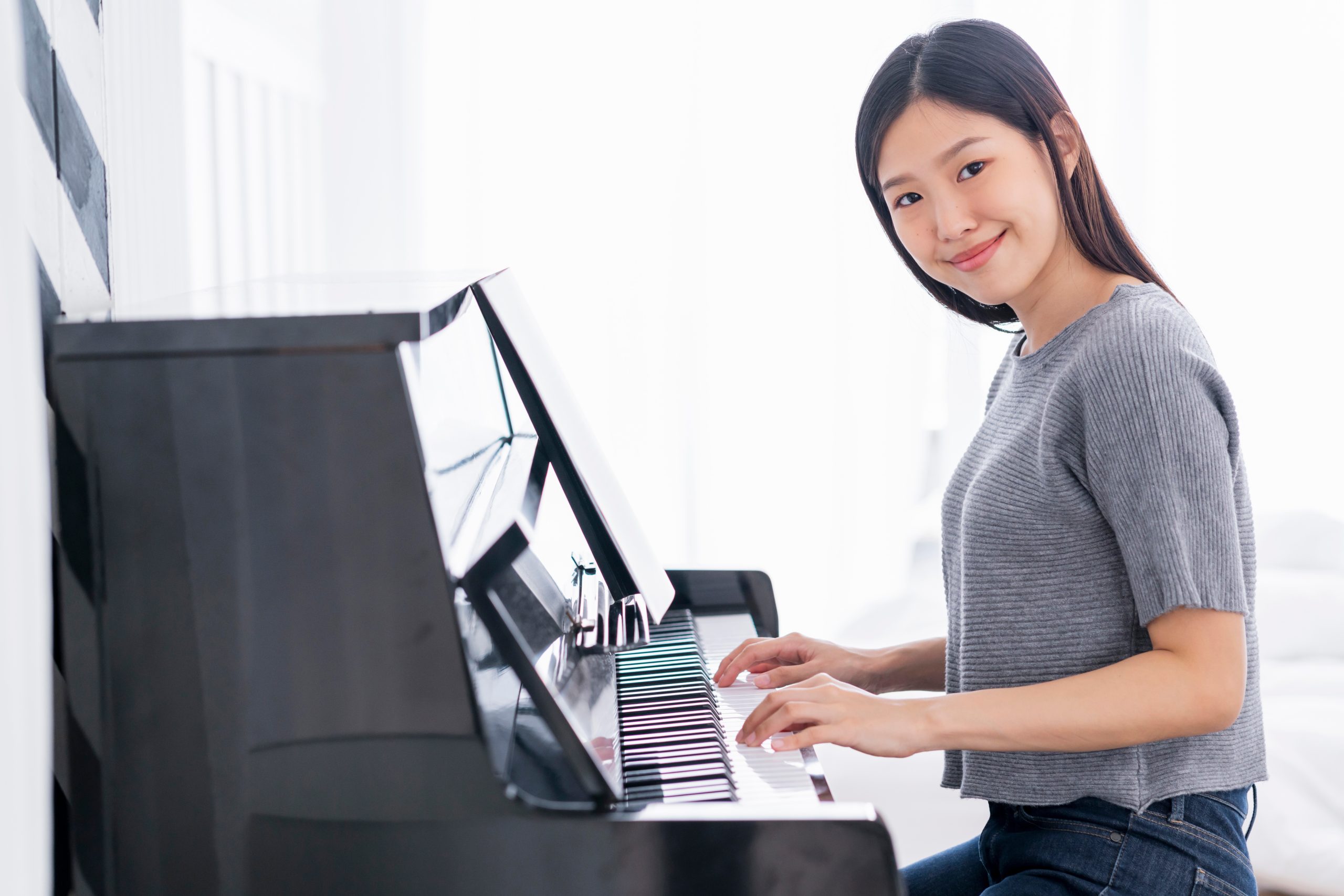 beautiful casual asian woman enjoy practicing piano relax and happiness home background